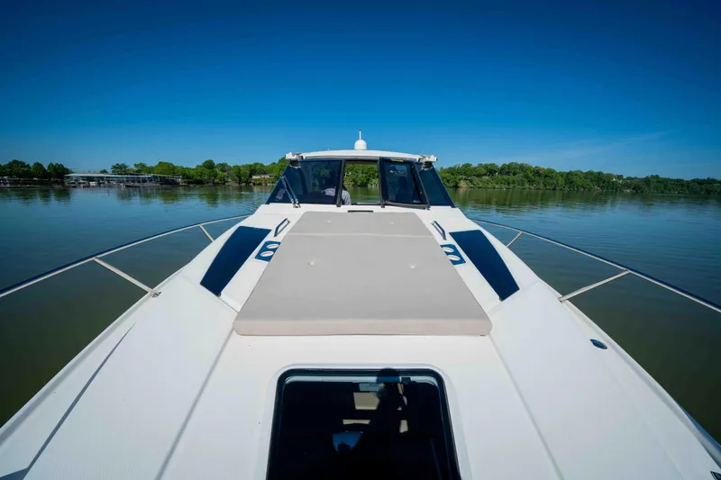 Slide: The Image of 2015 Regal 35 Sport Coupe on calm lake, clear sky, front deck view. - 36