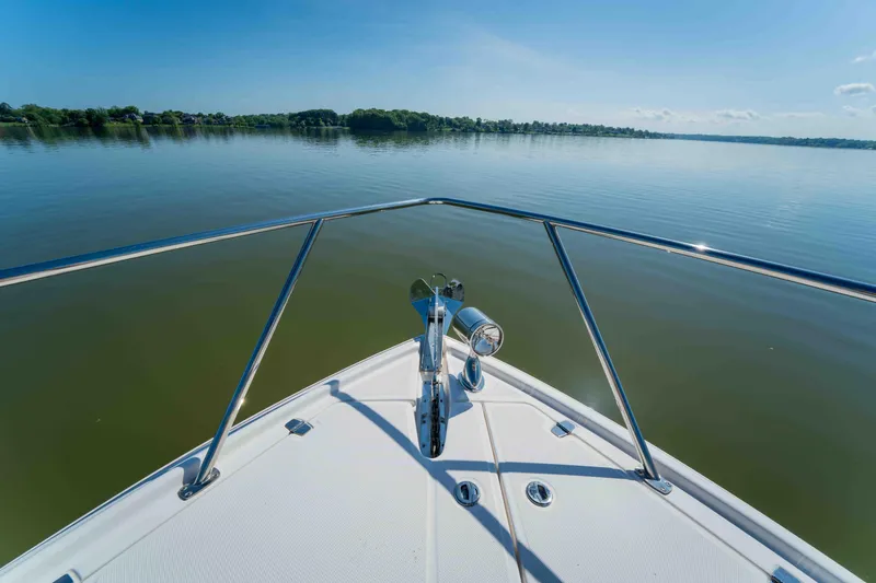 Slide: The Image of Bow view of 2015 Regal 35 Sport Coupe on calm lake waters. - 37