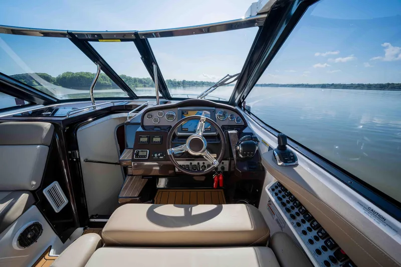 Slide: The Image of 2015 Regal 35 Sport Coupe cockpit with modern controls, overlooking serene water and clear skies. - 39