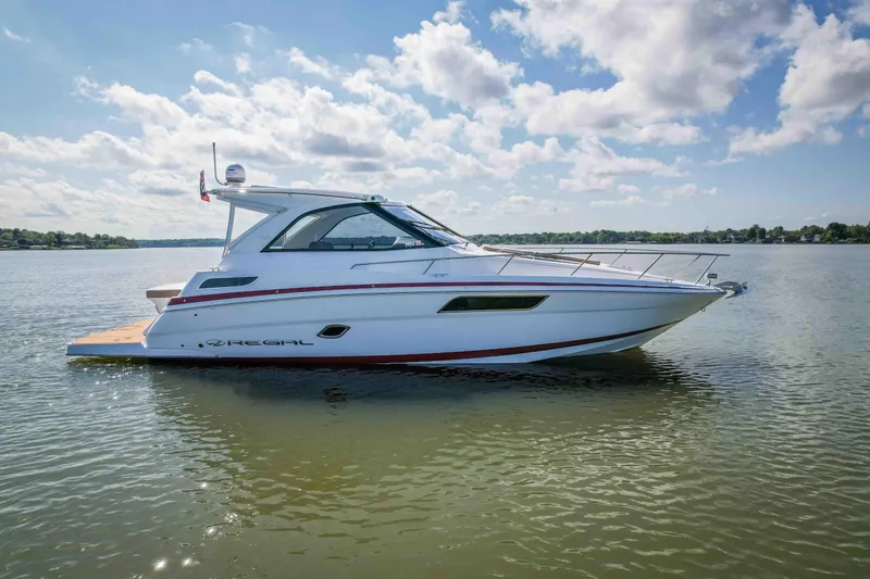 Slide: The Image of 2015 Regal 35 Sport Coupe boat on calm water under a partly cloudy sky. - 4
