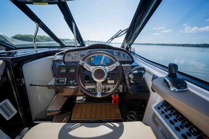 Slide: The Image of Cockpit of 2015 Regal 35 Sport Coupe with steering wheel and control panel, overlooking water. - 40