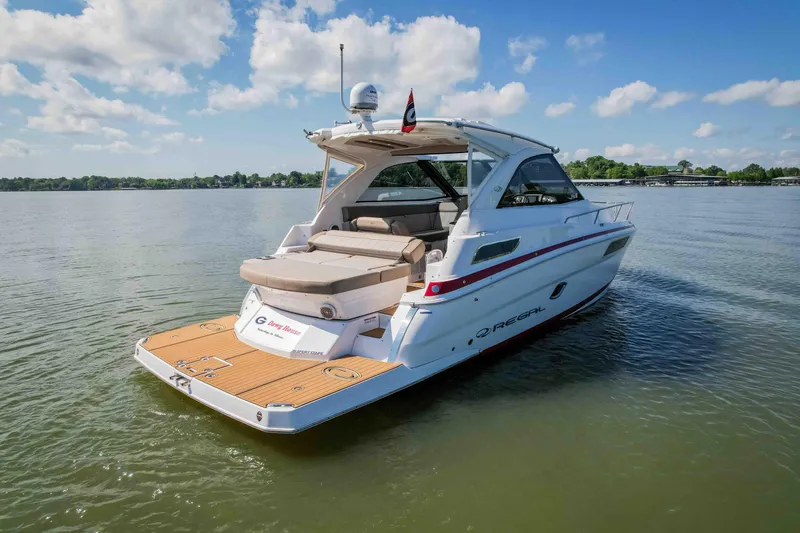 Slide: The Image of 2015 Regal 35 Sport Coupe boat on calm water under a blue sky. - 5