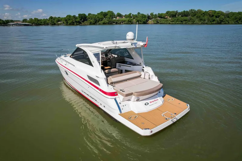 Slide: The Image of 2015 Regal 35 Sport Coupe on calm lake with lush green shoreline. - 8