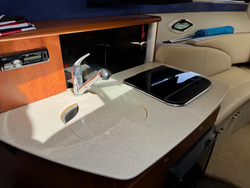 Slide: The Image of 2008 Bayliner 265SB interior with kitchenette, sink, and seating area. - 10