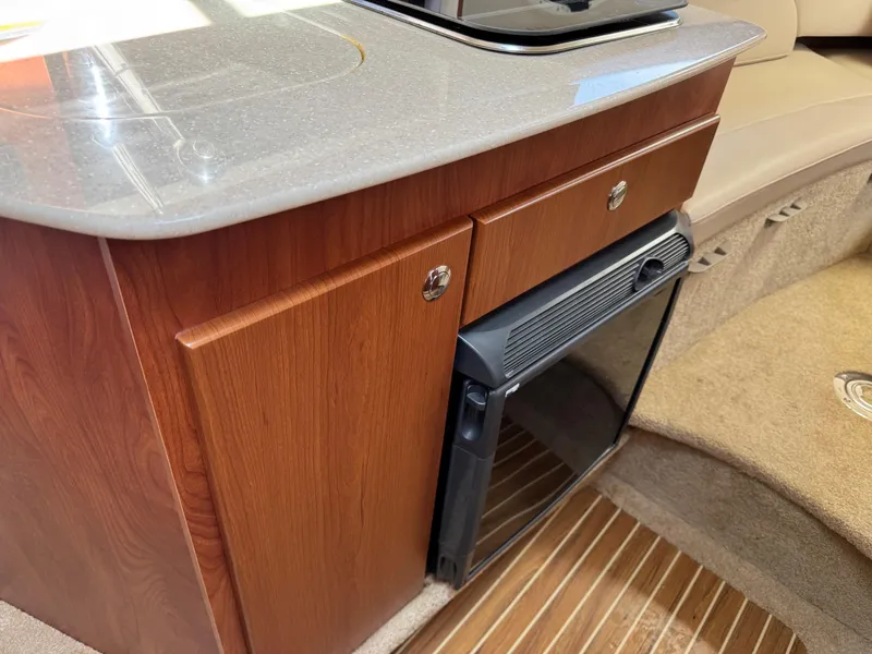 Slide: The Image of 2008 Bayliner 265SB interior with wood cabinetry and compact kitchen area. - 11