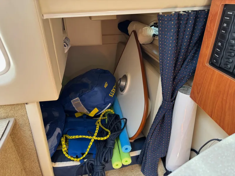Slide: The Image of Storage area in a 2008 Bayliner 265SB boat with life jackets and pool noodles. - 13