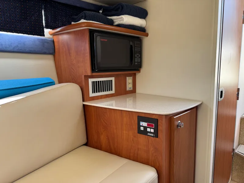 Slide: The Image of 2008 Bayliner 265SB interior with microwave, seating, and storage. - 15