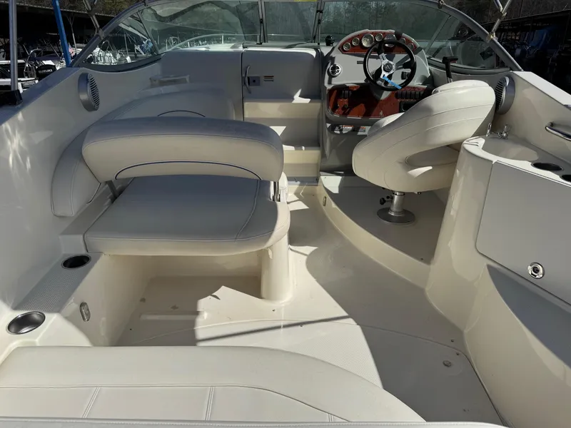 Slide: The Image of 2008 Bayliner 265SB boat interior with white seating and steering console. - 5