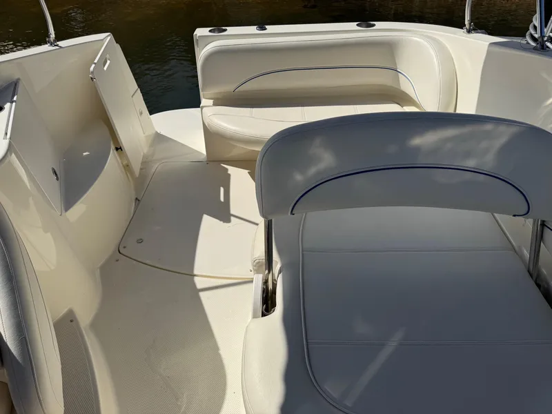 Slide: The Image of 2008 Bayliner 265SB boat interior with white seating and open storage compartments. - 6