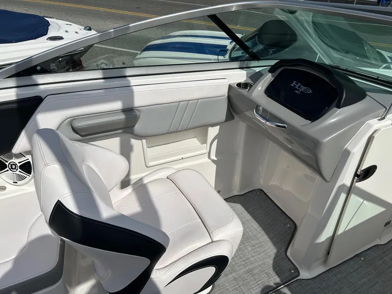 Slide: The Image of 2019 Chaparral 23 H2O Surf boat interior with white seating and dashboard. - 13