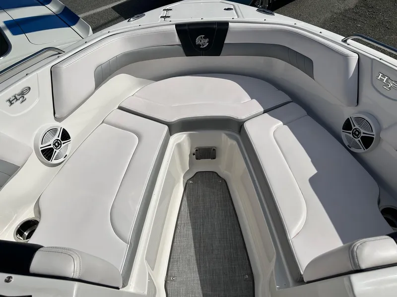 Slide: The Image of 2019 Chaparral 23 H2O Surf boat interior with cushioned seating and speakers. - 16