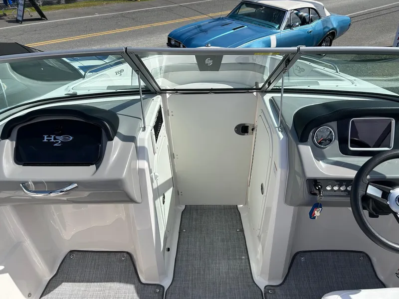 Slide: The Image of 2019 Chaparral 23 H2O Surf boat interior with dashboard and steering wheel. - 18