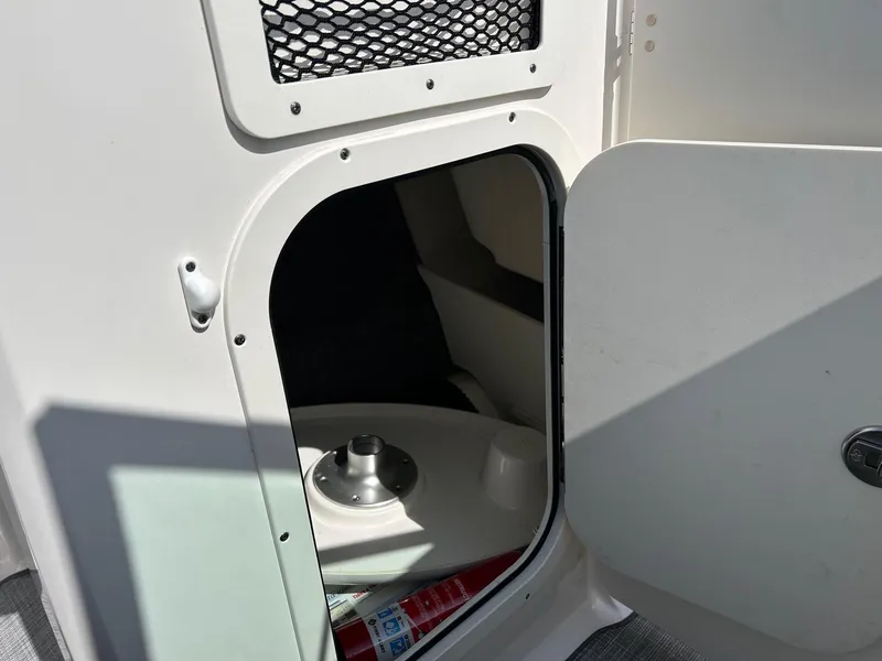 Slide: The Image of Storage compartment in a 2019 Chaparral 23 H2O Surf boat, featuring a secure latch. - 19