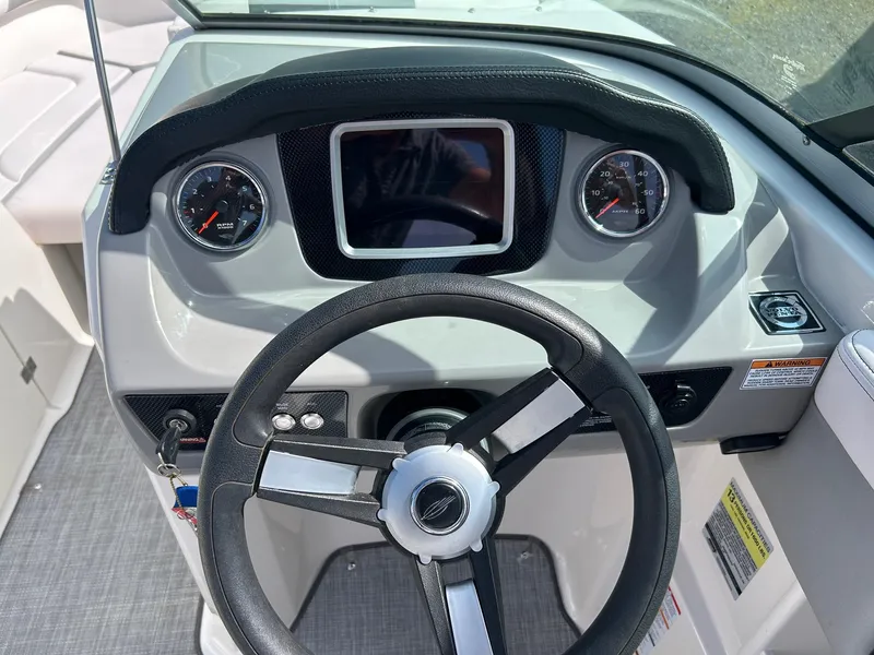Slide: The Image of 2019 Chaparral 23 H2O Surf boat dashboard with steering wheel and gauges. - 4