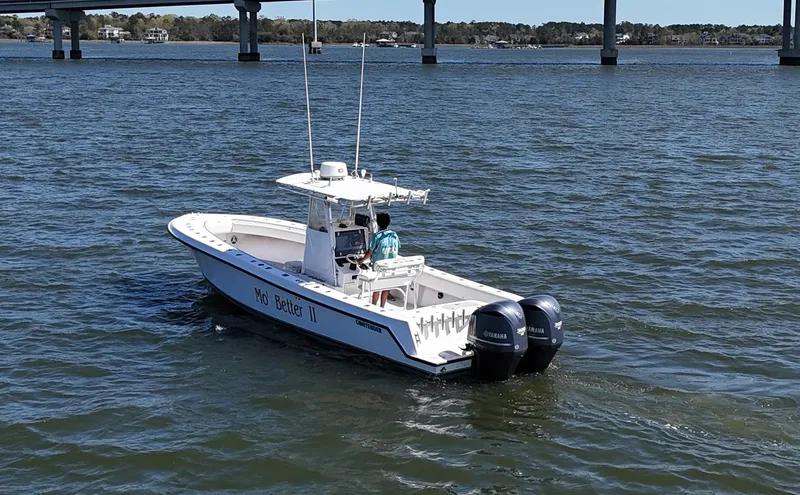 Slide: The Image of 2002 Contender 31 Center Console boat on water with dual outboard engines. - 0