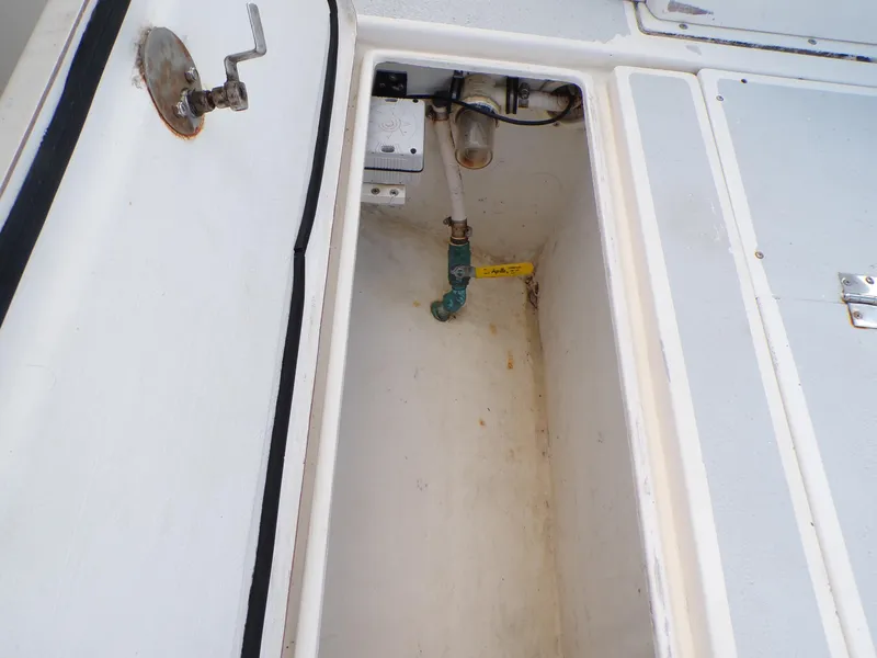 Slide: The Image of 2002 Contender 31 Center Console storage compartment with plumbing and wiring. - 19