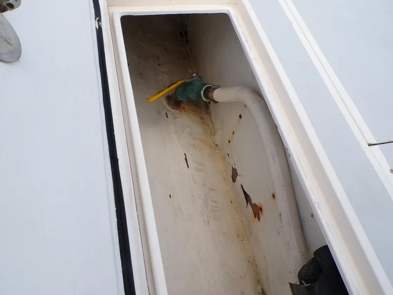 Slide: The Image of 2002 Contender 31 Center Console boat compartment with valve and hose. - 20