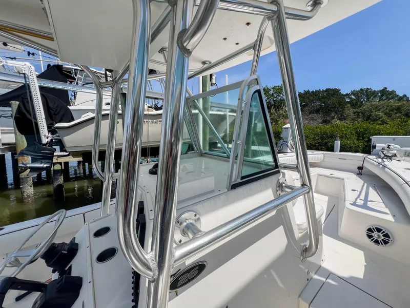 Slide: The Image of 2006 Regulator 26 FS boat with stainless steel railings and glass windshield, docked outdoors. - 12