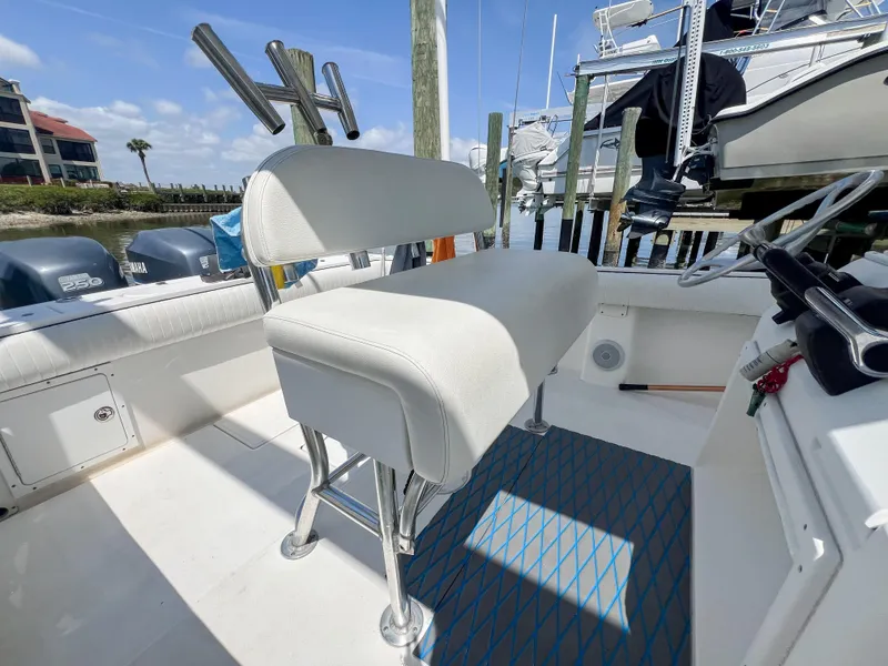 Slide: The Image of 2006 Regulator 26 FS boat interior with white seating and dual outboard motors. - 15