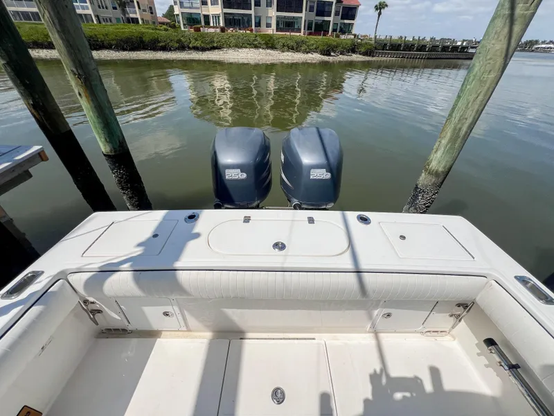 Slide: The Image of 2006 Regulator 26 FS boat with dual outboard motors docked by waterfront homes. - 16