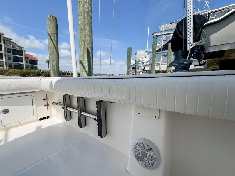 Slide: The Image of 2006 Regulator 26 FS boat interior with dock view, featuring white upholstery and speaker. - 21