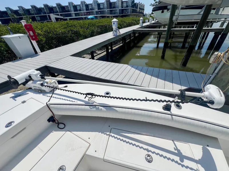 Slide: The Image of 2006 Regulator 26 FS boat docked, featuring a trolling motor and spacious deck. - 22