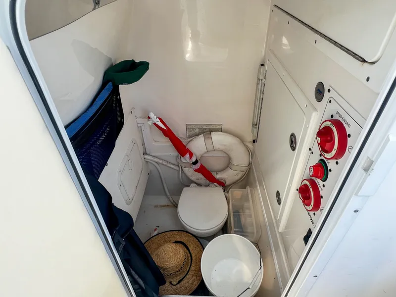 Slide: The Image of 2006 Regulator 26 FS boat interior with toilet, safety equipment, and storage. - 26