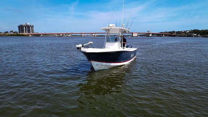 Slide: The Image of 2006 Regulator 26 FS boat on calm water with bridge and buildings in background. - 3