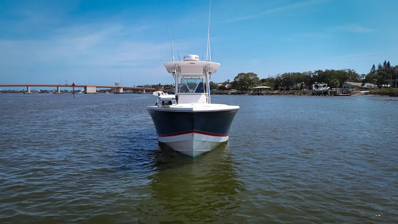 Slide: The Image of 2006 Regulator 26 FS boat on calm water with bridge and trees in background. - 4
