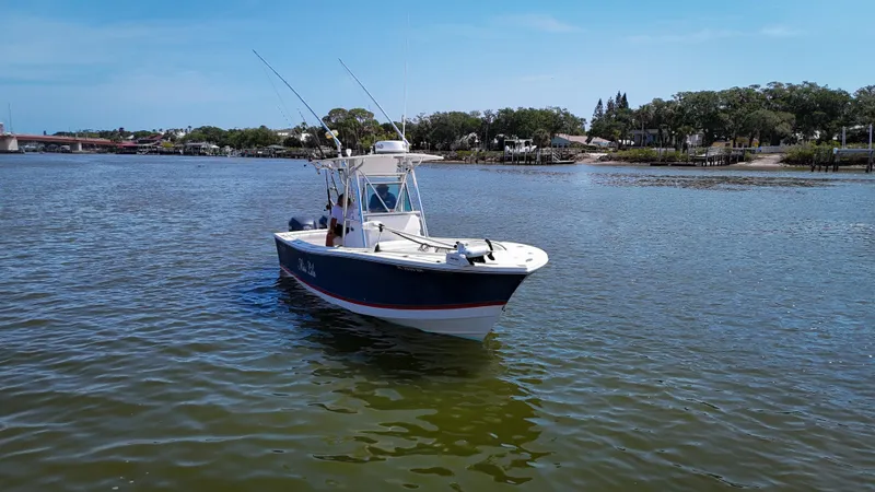 Slide: The Image of 2006 Regulator 26 FS boat on calm water, clear sky, and distant shoreline. - 8