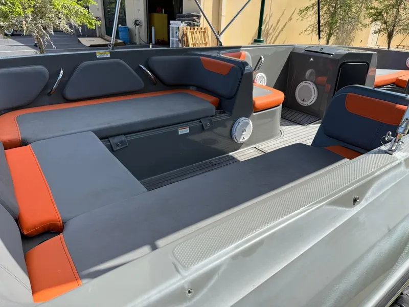 Slide: The Image of 2019 Bayliner Element E21 boat interior with gray and orange seating, showcasing spacious layout. - 2