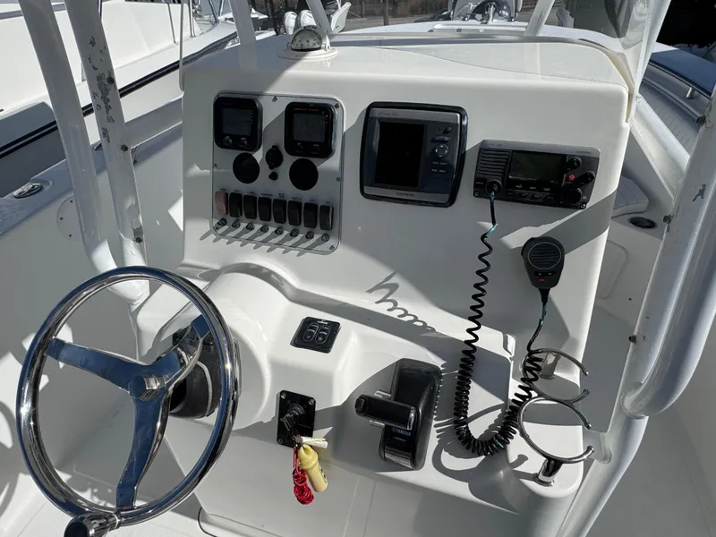 Slide: The Image of 2011 Tidewater 230 boat console with steering wheel, gauges, and communication equipment. - 12