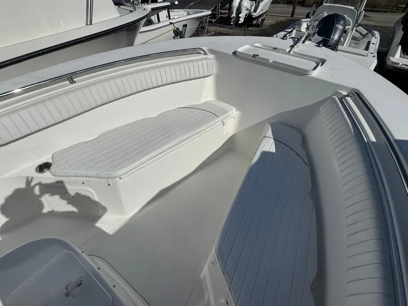 Slide: The Image of 2011 Tidewater 230 boat interior with white seating and spacious deck layout. - 16