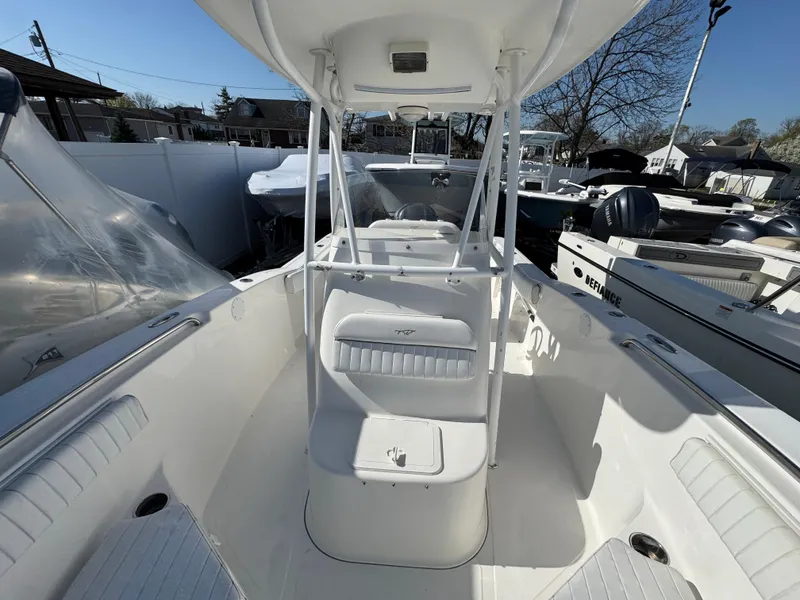 Slide: The Image of 2011 Tidewater 230 boat interior with seating and console, docked outdoors. - 18