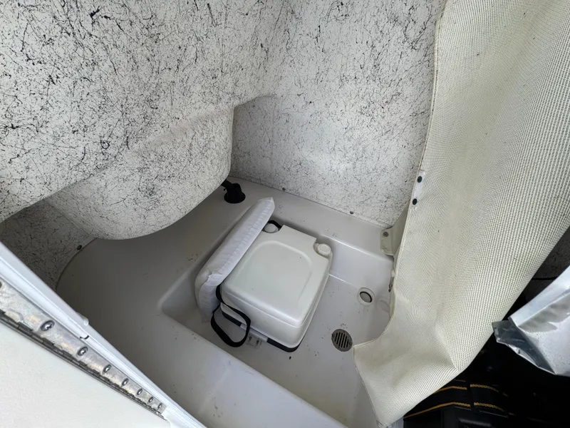 Slide: The Image of 2011 Tidewater 230 boat interior with portable toilet and privacy curtain. - 20
