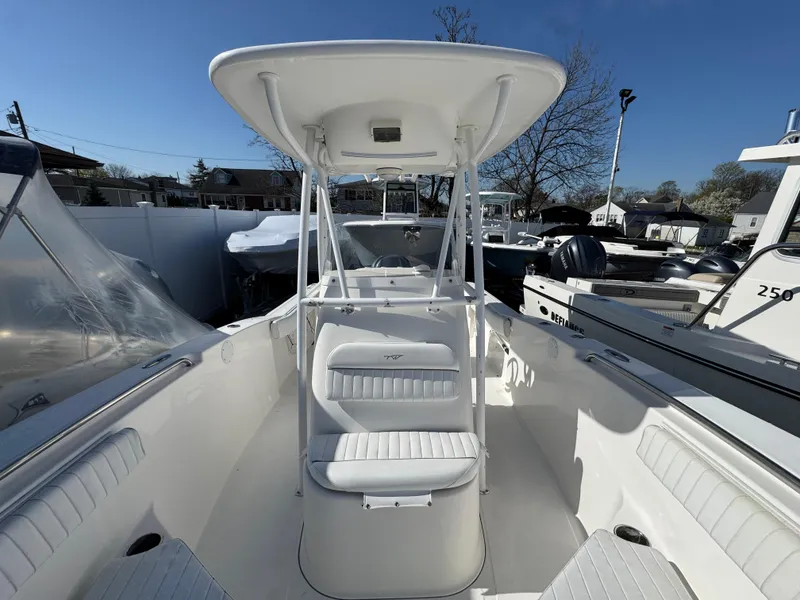 Slide: The Image of 2011 Tidewater 230 boat with T-top and seating, docked under clear blue sky. - 21