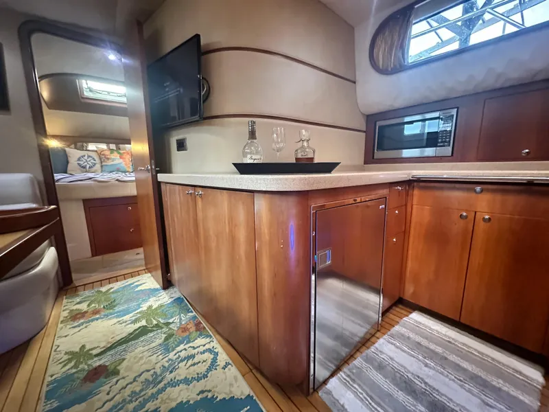 Slide: The Image of 2007 Chris-Craft Roamer 40 interior with modern kitchen, wood cabinetry, and cozy bedroom. - 45