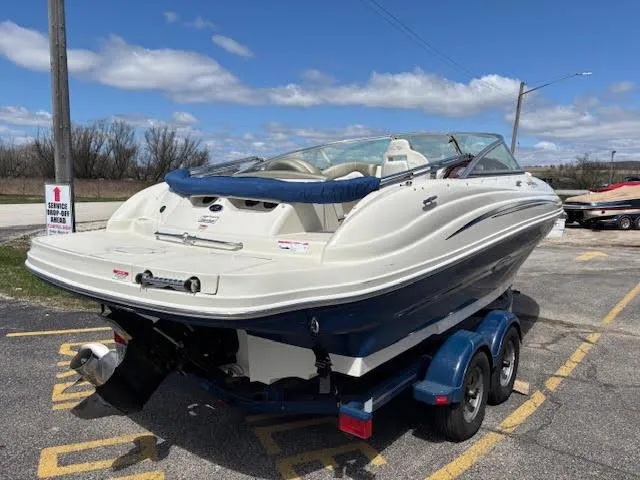 Slide: The Image of 2007 Sea Ray 200 Sundeck boat on trailer, parked outdoors under blue sky. - 12