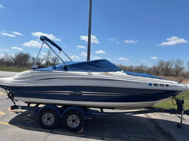 Slide: The Image of 2007 Sea Ray 200 Sundeck boat on trailer under clear blue sky. - 2