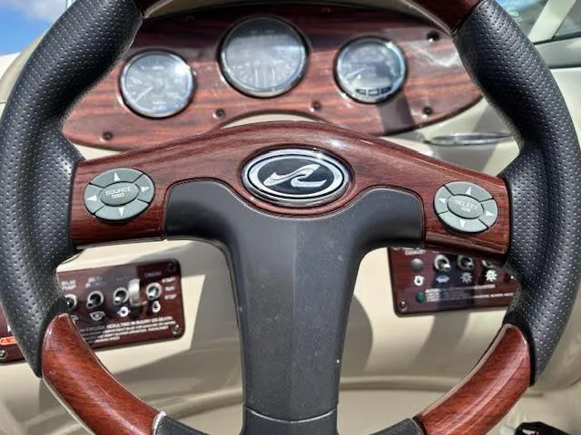 Slide: The Image of Steering wheel of a 2007 Sea Ray 200 Sundeck boat with wood accents and controls. - 27