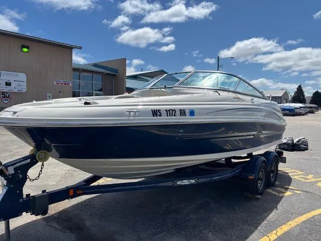 Slide: The Image of 2007 Sea Ray 200 Sundeck boat on trailer, parked outdoors under a partly cloudy sky. - 7