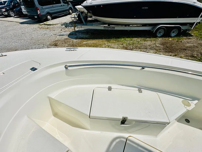Slide: The Image of 2014 Mako 204 CC boat interior with storage compartment, parked on gravel lot. - 14