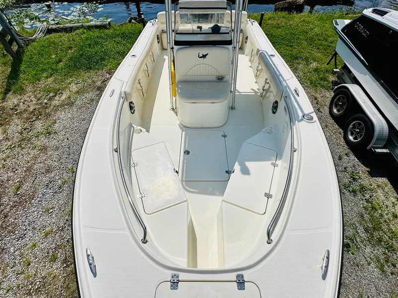 Slide: The Image of 2014 Mako 204 CC boat, top view, docked near water, showcasing spacious deck layout. - 16