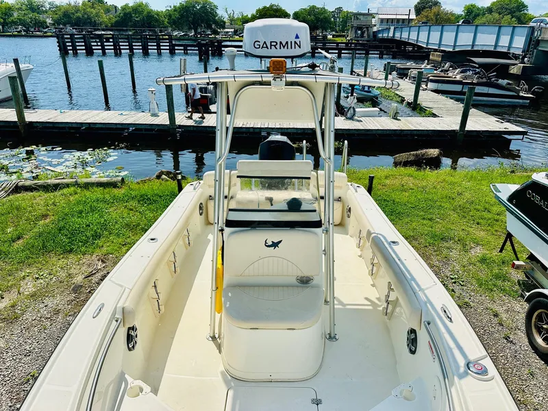 Slide: The Image of 2014 Mako 204 CC boat with Garmin equipment, docked by a scenic waterfront. - 17