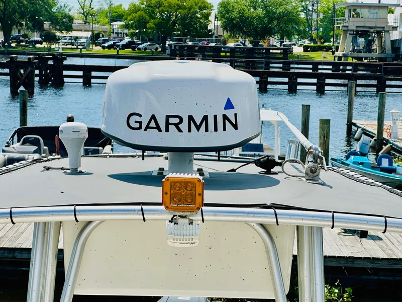 Slide: The Image of 2014 Mako 204 CC boat with Garmin radar, docked by a scenic waterfront. - 18