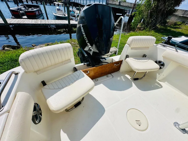 Slide: The Image of 2014 Mako 204 CC boat interior with seating and Mercury outboard motor. - 21