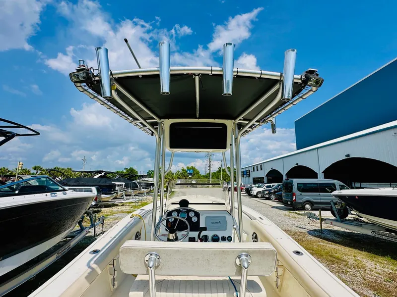 Slide: The Image of 2014 Mako 204 CC boat with T-top, parked outdoors under blue sky. - 8