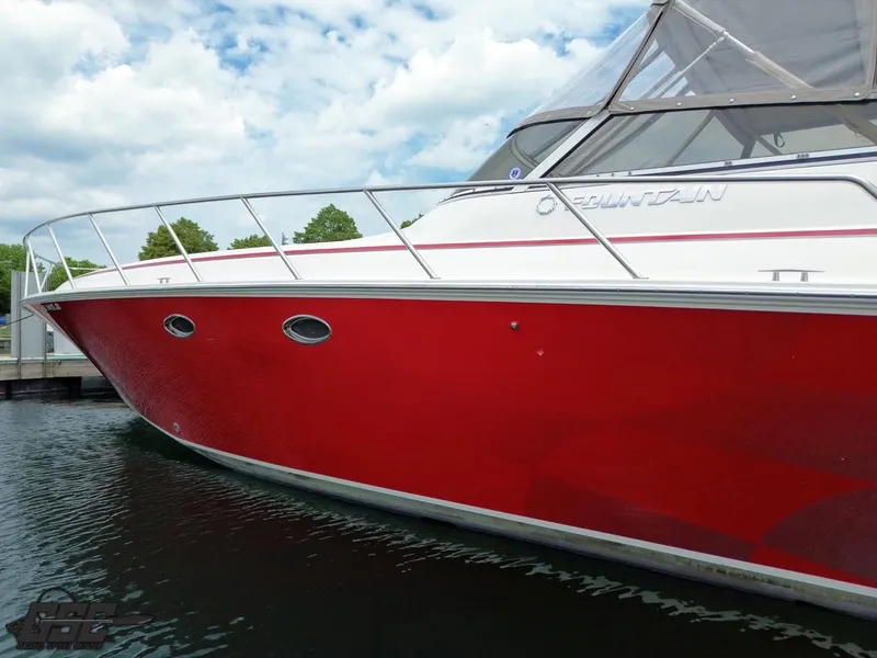 Slide: The Image of 2006 Fountain 48 Express Cruiser with red hull docked on a sunny day. - 10