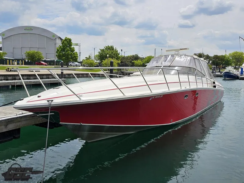 Slide: The Image of 2006 Fountain 48 Express Cruiser, red hull, docked in a marina under cloudy skies. - 11