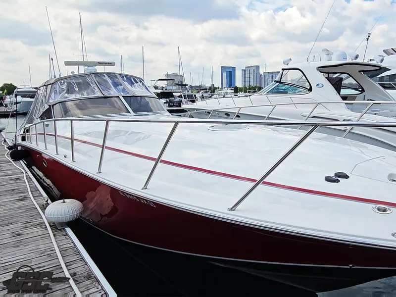 Slide: The Image of 2006 Fountain 48 Express Cruiser docked at marina, sleek design, red and white exterior. - 16